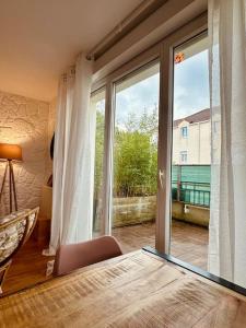 モンテヴランにあるDuplex Le G - proche Disneylandのベッドルーム1室(大きなガラスドア、バルコニー付)