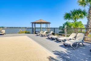 默特尔比奇Private Beach and Pool Access Murrells Inlet Condo!的甲板上一排椅子和一个凉亭