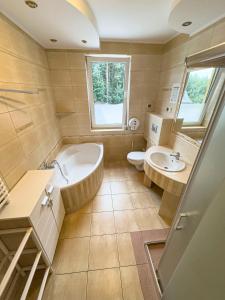 a bathroom with a tub and a toilet and a sink at Milten Turystyczna in Łuków
