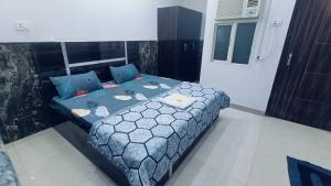 a bedroom with a bed with a blue comforter at Spiritual Apartment in Vrindāvan