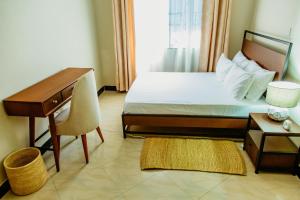 a hotel room with a bed and a desk and a desk at Kwetu Maili6Homes 02 in Moshi