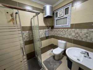 a bathroom with a toilet and a sink at Spacious 3BR Apt, 2 Baths, Gated Community - 903 in Sheikh Zayed +15 photos