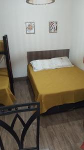 a bedroom with two beds and a chair at Ronald in Piriápolis