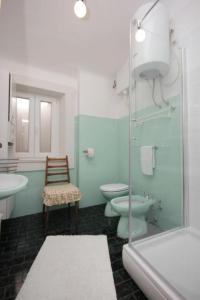 a bathroom with a toilet and a sink and a shower at House Korta in Cavtat