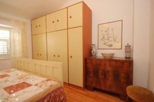 a bedroom with a bed and a wooden dresser at House Korta in Cavtat