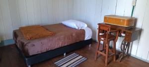 a small bedroom with a bed and a night stand at Refugio Paramo Trek Murillo in Murillo