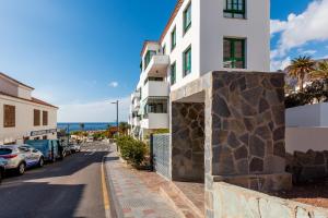 a building on a street next to the ocean at Stylish family home in Los Gigantes in Santiago del Teide