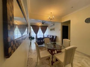 a dining room and living room with a table and chairs at 12pax Seaside Homestay Port Dickson 3R3B,Wifi,Beach,Pool,BBQ in Port Dickson