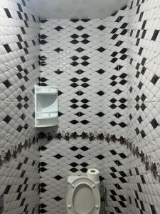 a bathroom with a toilet and a tiled wall at Yousef appartement in Taghazout +7 photos