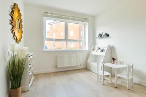 カンタベリーにあるModern Spacious House with Free Parking & Garden - Sleeps 6 - Perfect for Contractors & Familiesの窓、テーブル、椅子が備わる白い客室です。