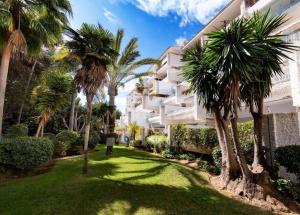 a yard in front of a building with palm trees at Beautiful Marbella Apartment in Marbella