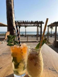 two drinks sitting on a table near the beach at Beautiful Marbella Apartment in Marbella