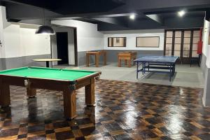 a room with a pool table and two tables at Studio 330 - aconchegante, 500m da Feirinha do Alto, com Garagem e Wi-Fi 500MB in Teresópolis