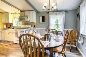 eine Küche mit einem Tisch und Stühlen sowie eine Küche mit einem Herd in der Unterkunft Lake Views and Fireside Bliss Cecil Cottage with Yard in Shawano