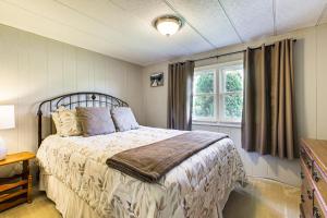 ein Schlafzimmer mit einem Bett und einem Fenster in der Unterkunft Lake Views and Fireside Bliss Cecil Cottage with Yard in Shawano