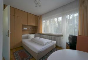 a small bedroom with a bed and a window at Appart International Boarding House in Würzburg