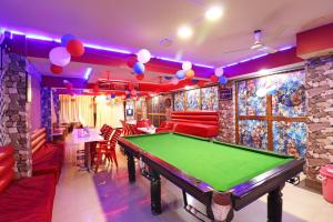 a bar with a pool table in a room with red booths at Hotel O Sher E Bengal in Durgāpur