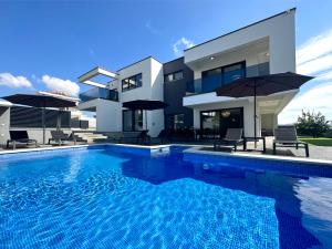 诺瓦利娅Fantasy Daydream Mansion的房子前面的一个大游泳池