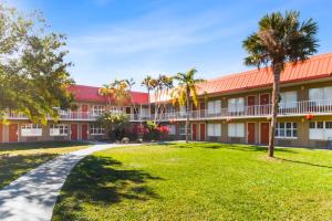 an exterior view of a building with palm trees at Vero Beach Inn & Suites Vero Beach I-95 in Vero Beach
