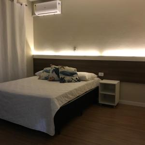 a bedroom with a bed with a light on it at Pousada Souza & Souza in Barra Velha