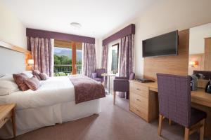 a hotel room with two beds and a television at Moorings Hotel in Fort William