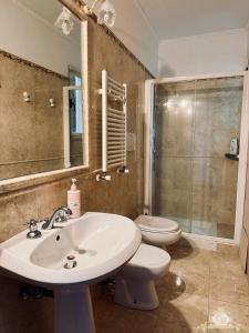 a bathroom with a sink and a toilet and a shower at Casa belvedere anzio in Anzio