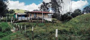 a small house on the side of a hill at Refugio Paramo Trek Murillo in Murillo