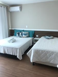 two beds in a hotel room with at Pousada Souza & Souza in Barra Velha