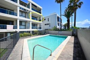 a swimming pool in front of a building at Alex Heads, Prime Location, Stunning Views in Alexandra Headland