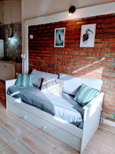 埃斯克尔FLAMENCOS Apart的一间有砖墙的房间里的一张床