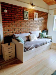 埃斯克尔FLAMENCOS Apart的一间有砖墙的房间里的一张床