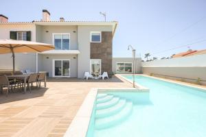 a villa with a swimming pool and a dining area at Dunas Villa in São Jacinto