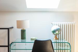 a glass table with a lamp and a globe on it at Fashionable Private Flat 15 min Walk to the Olympic Village in Milan +23 photos