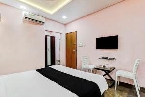 a bedroom with a bed and a desk and a tv at Townhouse Soni Inn in Rāipur