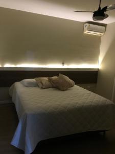 a bedroom with a bed with a ceiling fan at Pousada Souza & Souza in Barra Velha