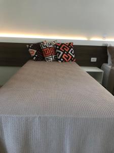 a bed with two pillows on top of it at Pousada Souza & Souza in Barra Velha