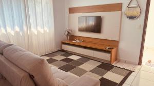 a living room with a couch and a television at Casa grande em bairro tranquilo in Pato Branco