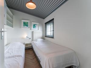 ein Schlafzimmer mit zwei Betten und einem Fenster in der Unterkunft Beachhouse II in Bergen aan Zee
