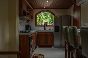 a kitchen with a refrigerator and a window at Arenal Ginger Home in Fortuna +37 photos