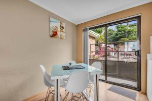 a dining room with a table and chairs and a window at Hydra 8 in Merimbula
