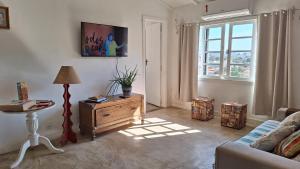 a living room with a couch and a table and a window at Casas Loft Búzios in Búzios