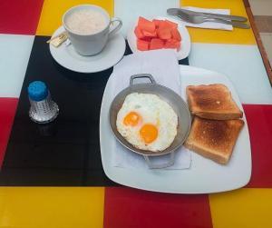 a breakfast plate with eggs and toast and a cup of coffee at Hotel Casa La Riviera in Bogotá