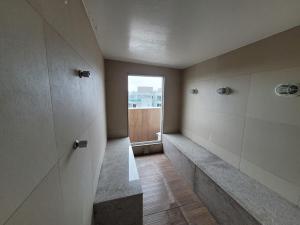 an empty hallway with a door to a window at HOTEL BOSSA NOVA 224 - Ótimo Apto com cozinha para até 03 hóspedes in Cabo Frio