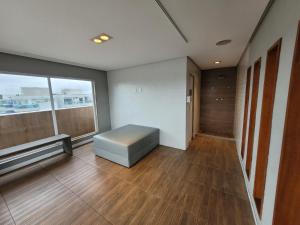a empty room with a bench and a large window at HOTEL BOSSA NOVA 224 - Ótimo Apto com cozinha para até 03 hóspedes in Cabo Frio