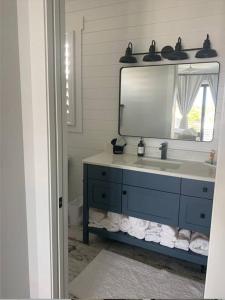 ein Badezimmer mit einem blauen Waschbecken und einem Spiegel in der Unterkunft Newly built home in Cudjoe Key in Cudjoe Key