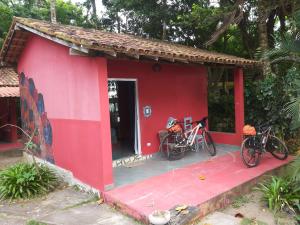 a red house with two bikes parked outside of it at Pousada ZEN Cumuruxatiba in Cumuruxatiba