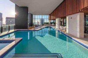 een groot zwembad met blauw water in een gebouw bij Coastal Chic 2 Bed Apt in Broadbeach in Gold Coast