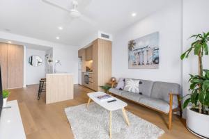 een woonkamer met een bank en een tafel bij Coastal Chic 2 Bed Apt in Broadbeach in Gold Coast