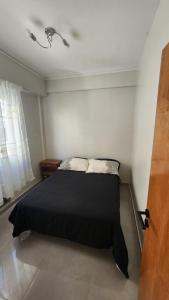 a bedroom with a black bed in a room at Micro-centro BA in Buenos Aires