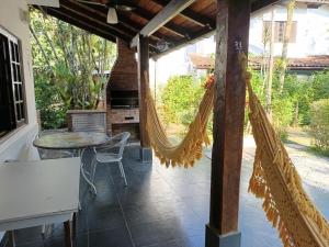 a patio with a hammock and a table at Chalé Recanto do Barão in Boicucanga